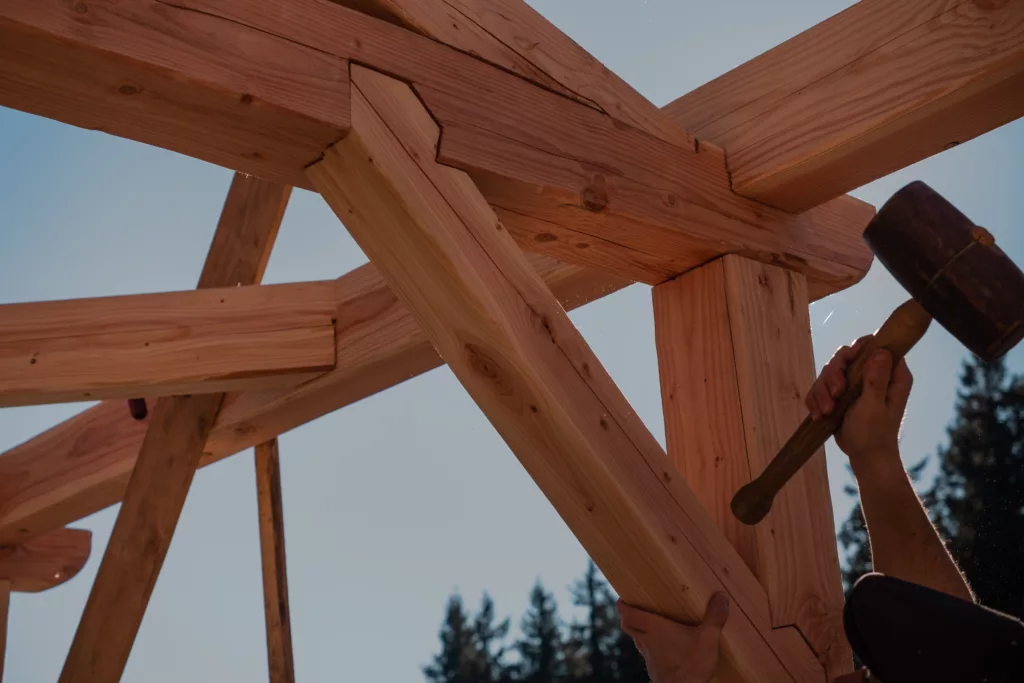 charpente traditionnelle, travail à la main avec un maillet en bois