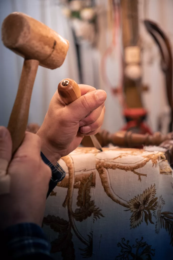 travail sur une assise de siège, dégarnissage à l'aide du maillet en bois et ciseau à bois