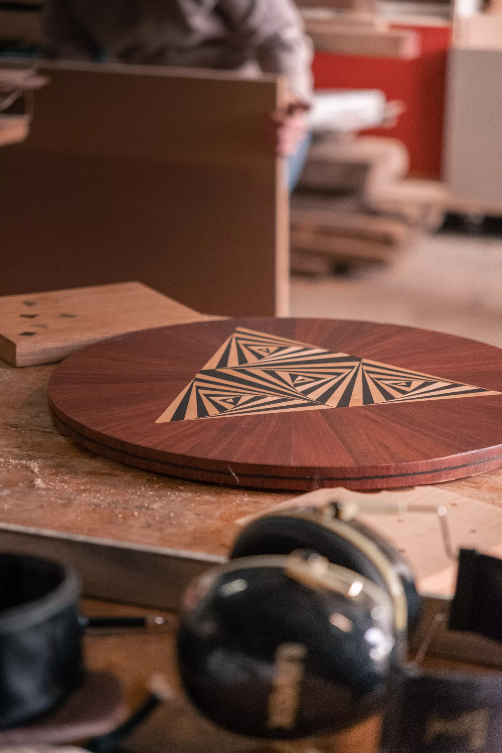 pièce de bois foncé ronde avec un triangle au centre marqueté en bois clair et brun