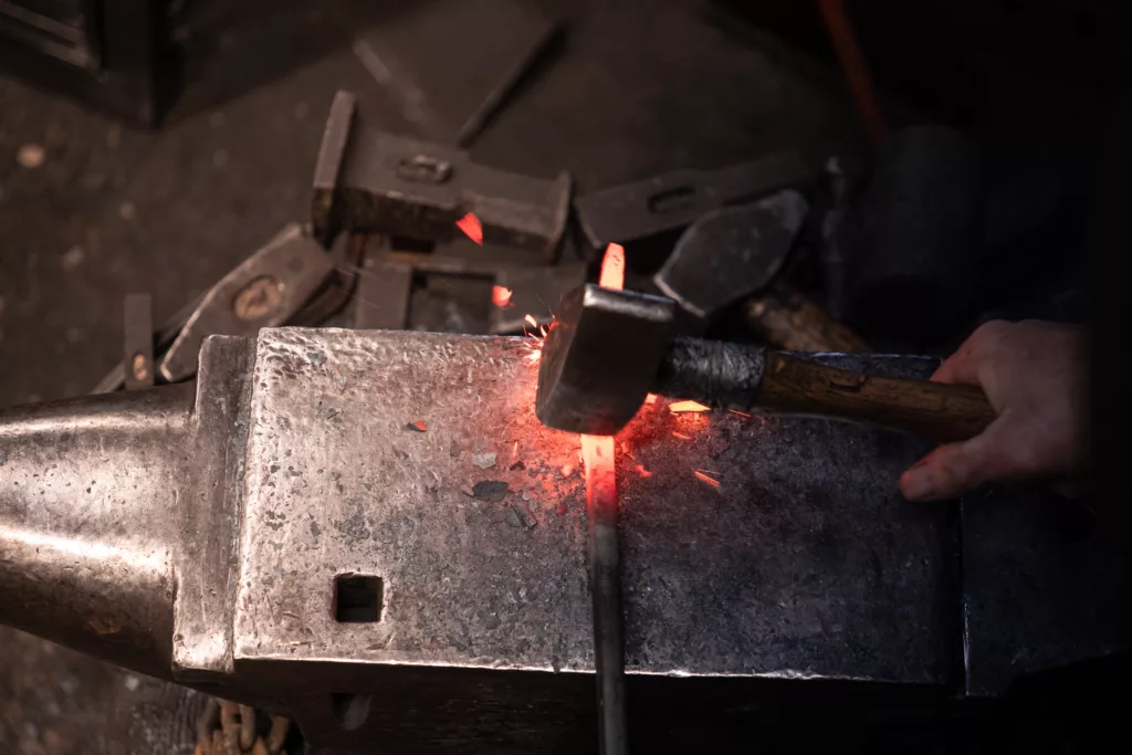 travail d'une pièce au marteau et à l'enclume, chauffée au rouge, sortie de la forge