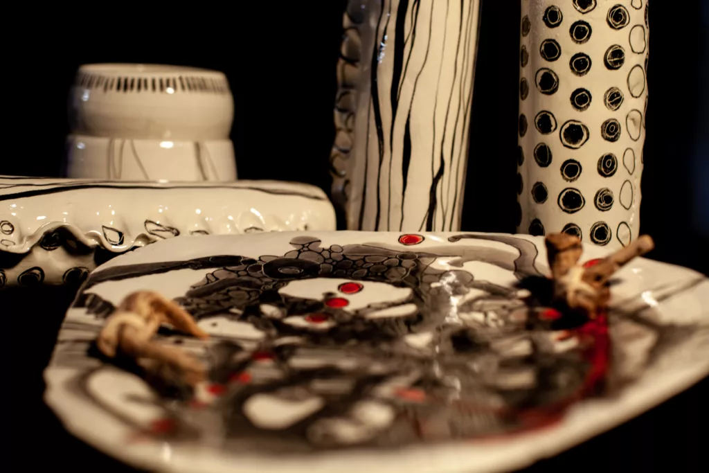 plusieurs pièces décorées, peintures ton noir, rouge, gris, sur céramique blanchce