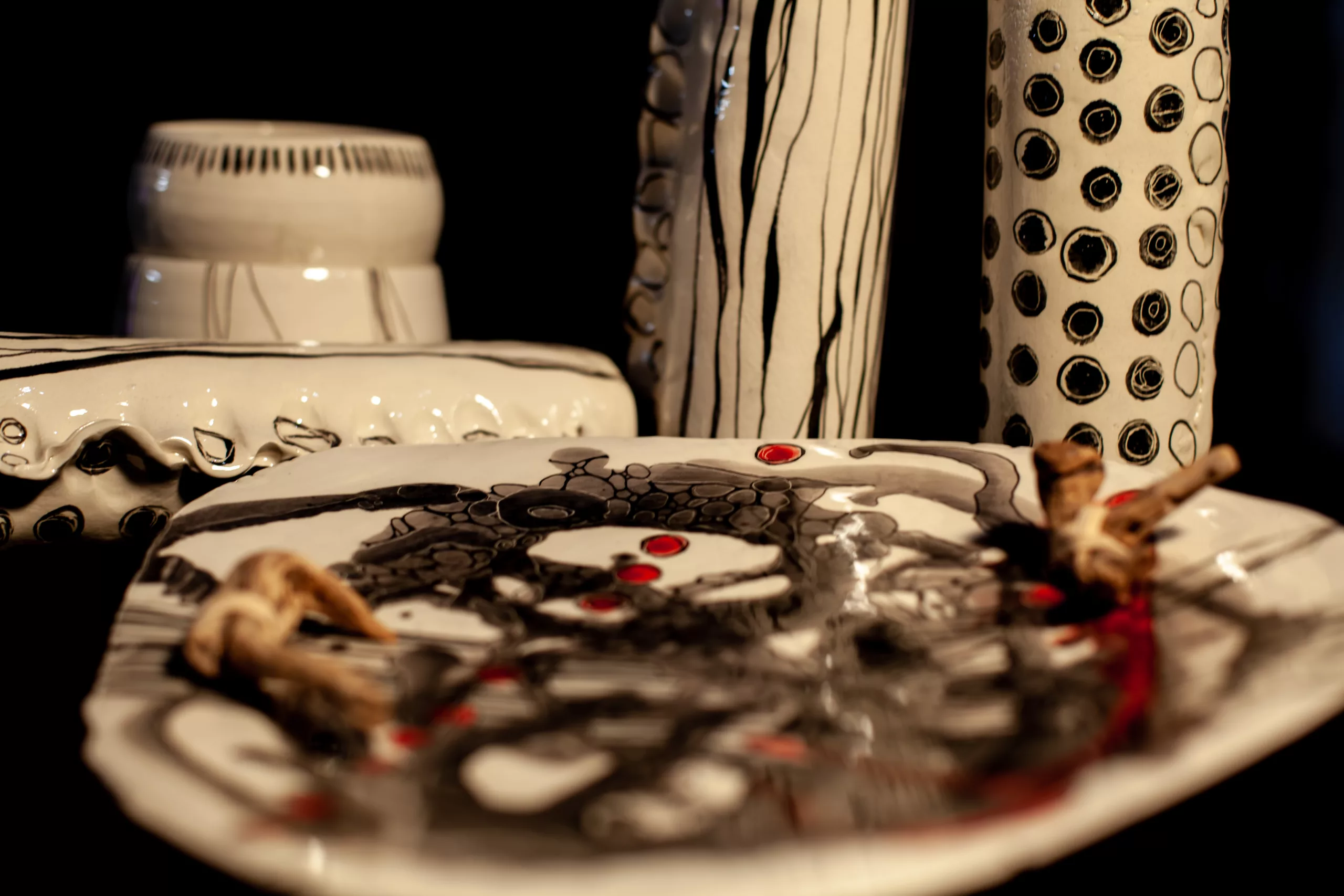 plusieurs pièces décorées, peintures ton noir, rouge, gris, sur céramique blanchce
