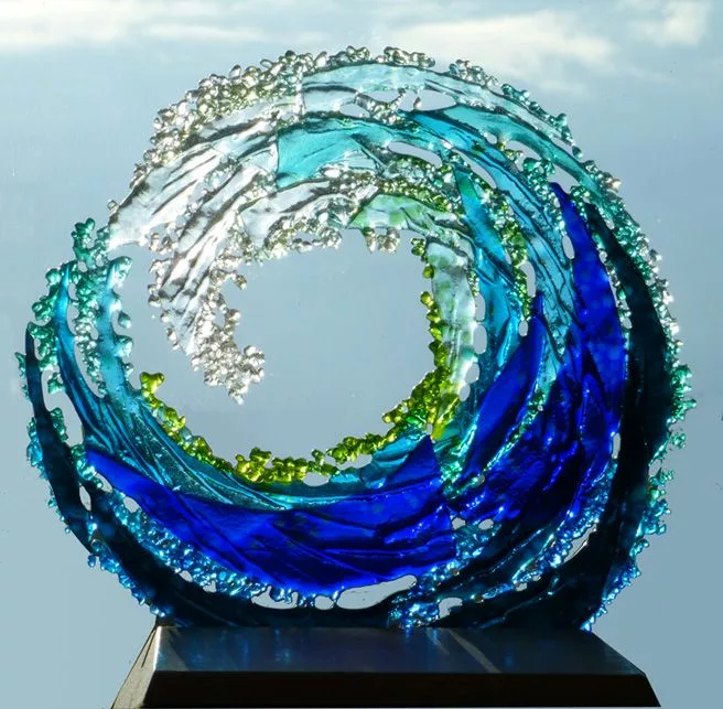 pièce réalisée en verre, de forme arrondie, donnant un effet de vague dans un dégradé de couleurs allant du transparent au bleu très foncé, en passant par du vert, et des tons de bleus différents