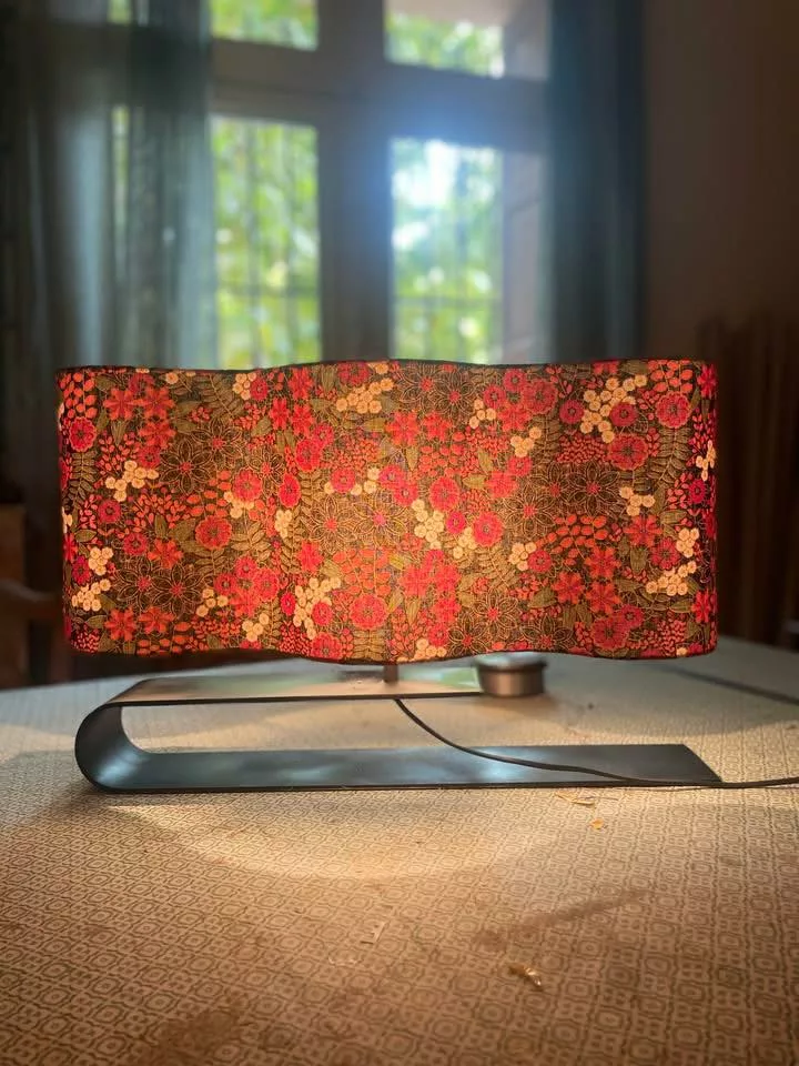 lampe de table sur pied avec un abat jour réalisé en tissu fleuri tons rouge, jaune et marron